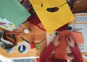 A stock photo that shows a view of a child working ona craft project from above.