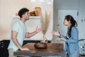 A stock photo of a couple arguing in a kitchen.