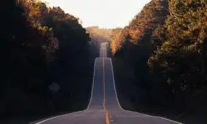 A stock photo that shows a hilly road stretching forward.