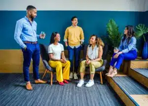 A stock photo of a group of people sitting in a colorful room.