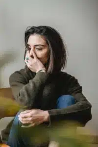 A stock photo of a white woman with dark hair looking sad with her hand over the bottom half of her face. |Why It’s Important to Talk About Grief (And 3 Tips for How to Do It) Blog